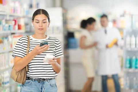 Pharmacy visitor scans a QR code and reads the composition of the medicine on Foto stock