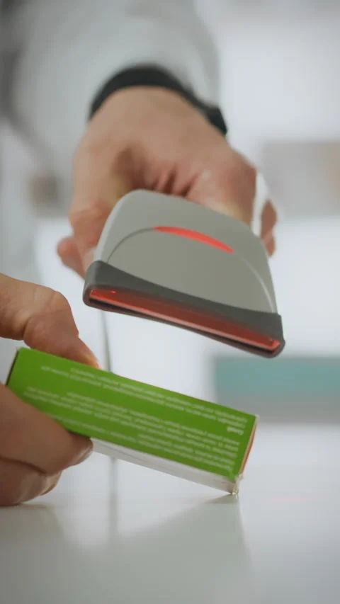 Pharmacy worker efficiently scans medication package for customer assistance Stock Footage 331677781