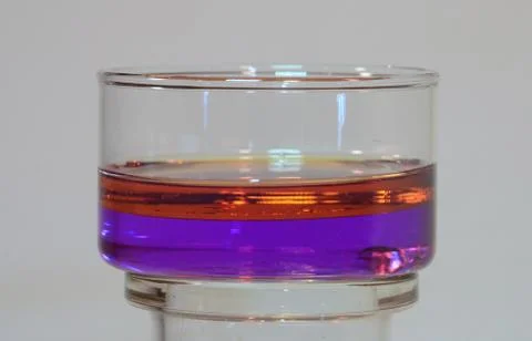 Phase separation between two liquids of different colors. Upper layer is oil, Stock Photos