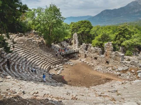 PHASELIS, TURKEY - May 19, 2018. Tourists walk into ruins of amphitheatre of  Stock Photos