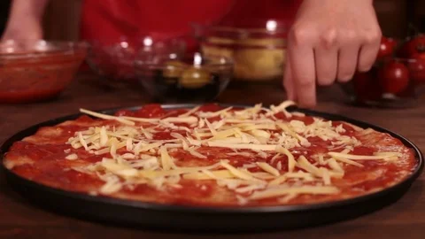 Phases of making a pizza - putting on the grated cheese Stock Footage 80104071