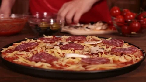 Phases of making a pizza - putting on the mushroom slices Stock Footage 80104141
