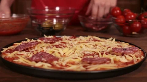 Phases of making a pizza - putting on the salami slices Stock-Footage 80104095