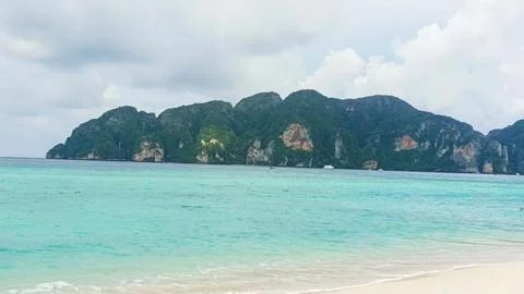 Phi Phi beach with turquoise water and a lush green mountain coastline 库存照片