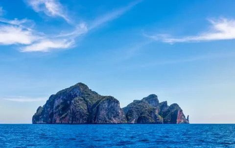 Phi Phi Lay island with tall cliffs and mountains, blue shy and white clouds Stock Photos
