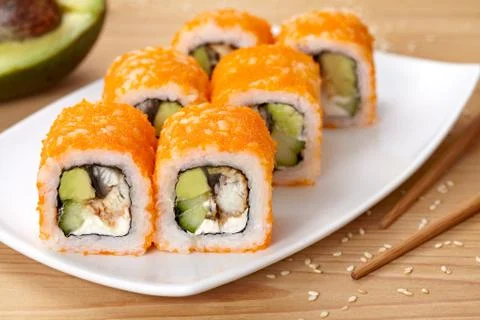 Philadelphia sushi roll with eel, avocado, cream cheese, cucumber and tobiko Stock Photos