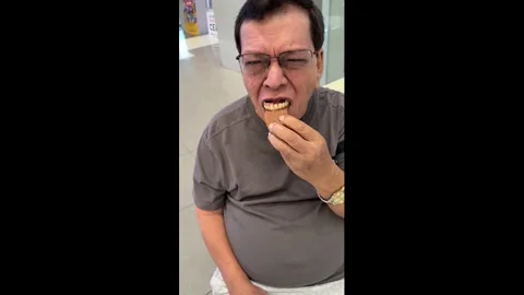 Philippines: Man struggles with cookie on dentures in Cebu, Philippines Stock Footage 330849632