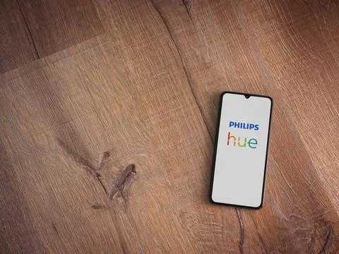 Philips Hue app launch screen on smartphone on wooden background Stock Photos