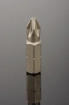 Philips screwdriver bit isolated on the black reflective background Stock Photos