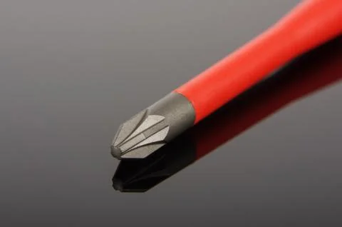 Philips screwdriver tip macro close up isolated on the black reflecting surfa Stock Photos