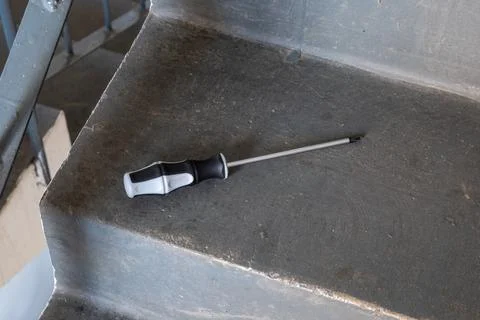 Phillips screwdriver tool with a magnetized tip on a concrete step, repair Stock Photos