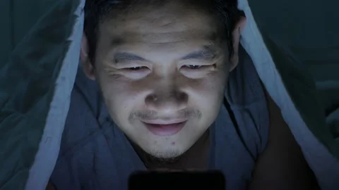 Phone addicted, man using smart phone on bed at midnight Stock Footage 141886662