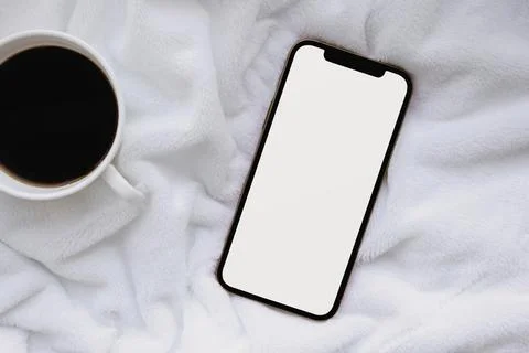Phone and coffee on the bed Stock Photos