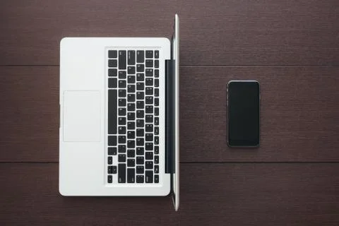 Phone and laptop computer on table top view Stock Photos
