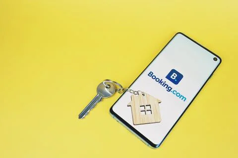 Phone with Booking com logo, key with house key chain Stock Photos