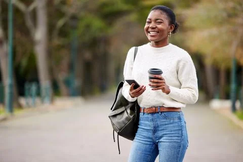 Phone, books and coffee with an african student woman on her commute to Stock Photos