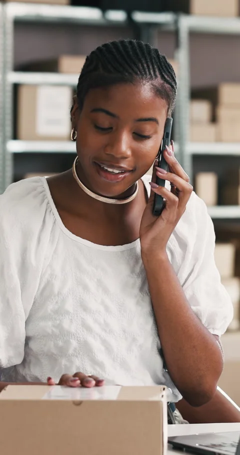 Phone call, box and black woman on laptop in logistics for shipping enquiry Stock Footage 332039383