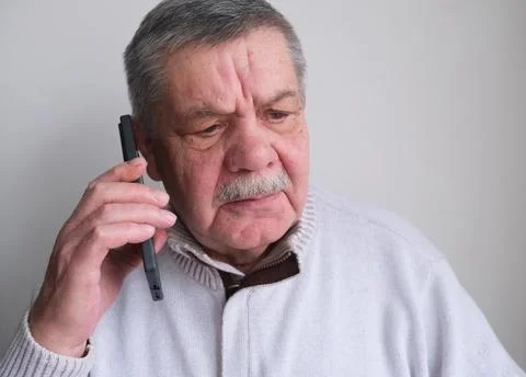 A phone call, laughter, and an elderly man in a house, living room, and a conver Stock Photos
