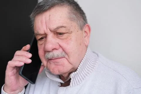 A phone call, laughter, and an elderly man in a house, living room, and a conver Stock Photos