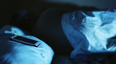 Phone calls late at night while man sleeping and he is angry waking in the room Stock Footage 64923156