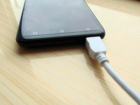 Phone at charge on a table Фото