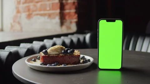 Phone with chroma key screen and delicious brioche dessert with cheese cream and Stock Footage 253577833