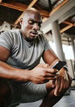 Phone, fitness and sweat with a black man athlete checking his social media Stock Photos