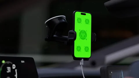 A phone with a green mockup screen is mounted on a car windshield Stock Footage 292909604