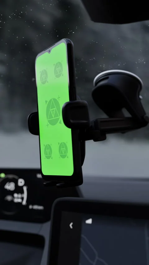 A phone with a green mockup screen is mounted on a car windshield Stock Footage 292909727