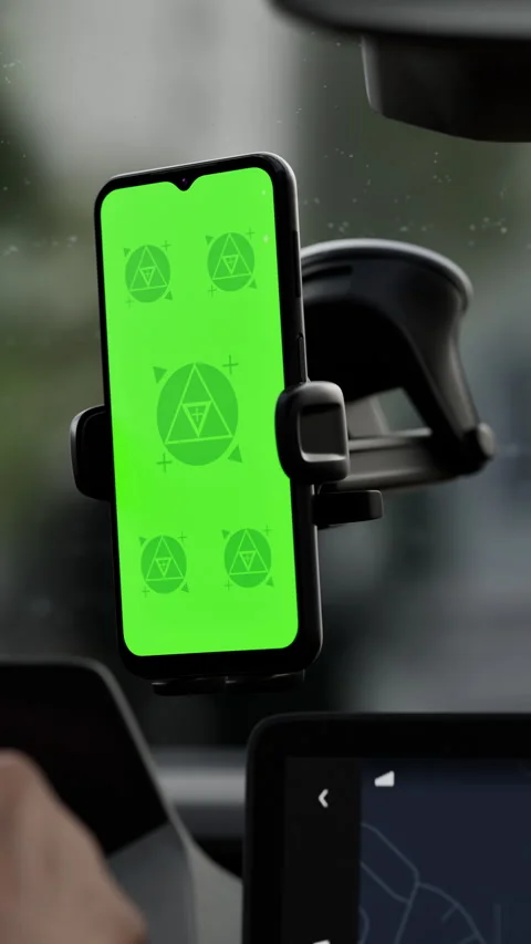A phone with a green mockup screen is mounted on a car windshield Stock Footage 292910413