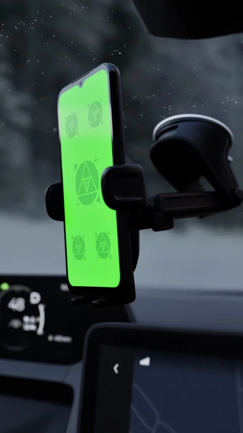 A phone with a green mockup screen is mounted on a car windshield Stock Footage 292910416