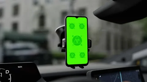 A phone with a green mockup screen is mounted on a car windshield Stock Footage 292910425