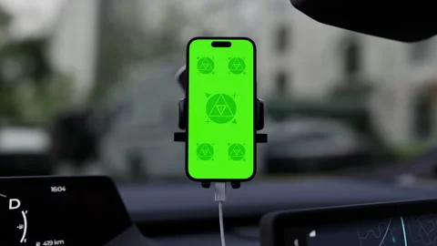 A phone with a green mockup screen is mounted on a car windshield Stock Footage 292910473