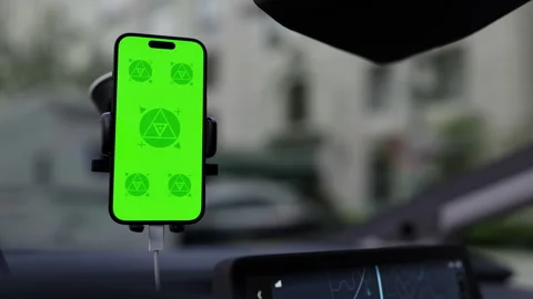 A phone with a green mockup screen is mounted on a car windshield Stock Footage 292910478