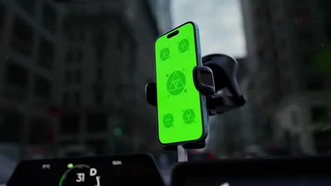 A phone with a green mockup screen is mounted on a car windshield Stock Footage 292910545