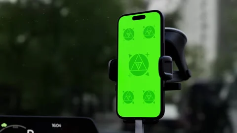 A phone with a green mockup screen is mounted on a car windshield Stock Footage 292910547