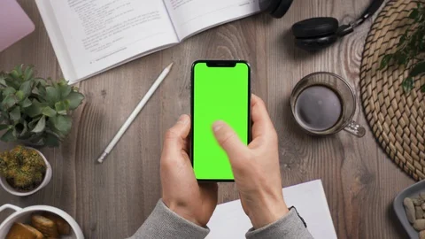 Phone with green screen chroma key in male hands. Thumb swipe left and tap likes 動画素材 129311244