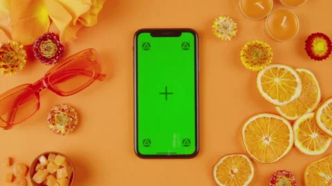 Phone with green screen chroma key on orange background close up, top view Stock Footage 247143604