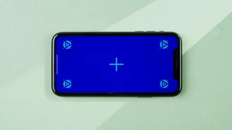 Phone with green screen chroma key on orange background close up, top view Stock Footage 247919720