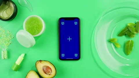 Phone with green screen chroma key with fresh avocado, green cream, lipstick and Stock Footage 253577305