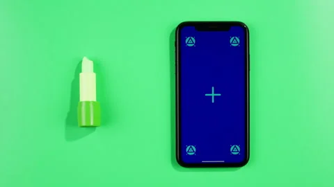 Phone with green screen chroma key on green background close up, top view with Stock Footage 256684680