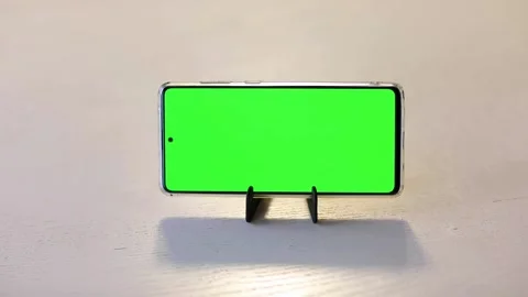 Phone with green screen stands on the stand, hand taps the screen 2 Stock Footage 160885123
