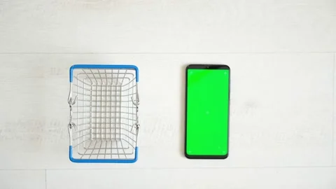 Phone with green screen on the table with notebook and purse view from top Stock Footage 141912491