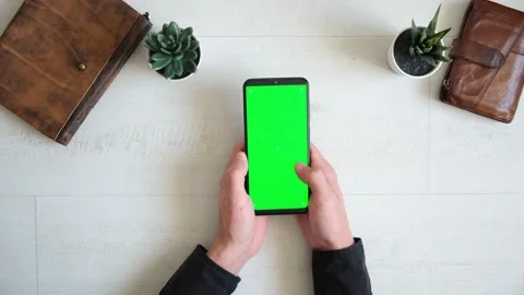 Phone with green screen on the table with notebook and purse view from top Stock Footage 143528706