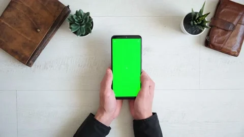 Phone with green screen on the table with notebook and purse view from top Stock Footage 147123593