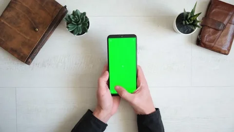 Phone with green screen on the table with notebook and purse view from top Stock Footage 147385683