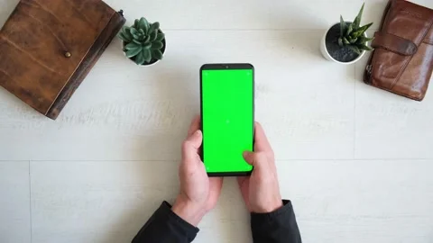 Phone with green screen on the table with notebook and purse view from top Stock Footage 149406392