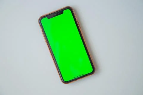 The phone with a green screen is on a white background. Stock Photos