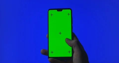 Phone in the hand close up isolated at blue background. Phone screen is blue Stock Footage 128677700