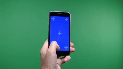 Phone in the hand close up isolated at green background. Phone screen is blue Stock Footage 102760720